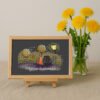 Framed cross stitch artwork featuring two cats in love with warm colors, dreamy trees and gentle decorative elements