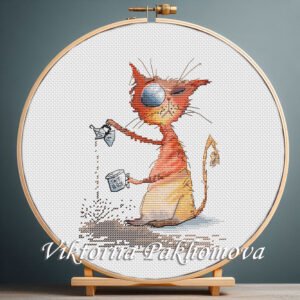 Cross stitch embroidery of a funny ginger cat holding a coffee cup with bright expressive details, displayed in a wooden hoop