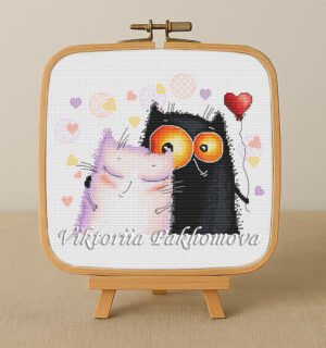 Cross stitch embroidery of two romantic cats with colorful hearts and playful details, displayed in a wooden hoop