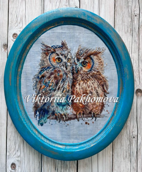 Framed romantic owls cross stitch design with warm colors, expressive bird couple embroidery