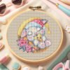Cross stitch embroidery of a sleeping bunny displayed in a wooden hoop