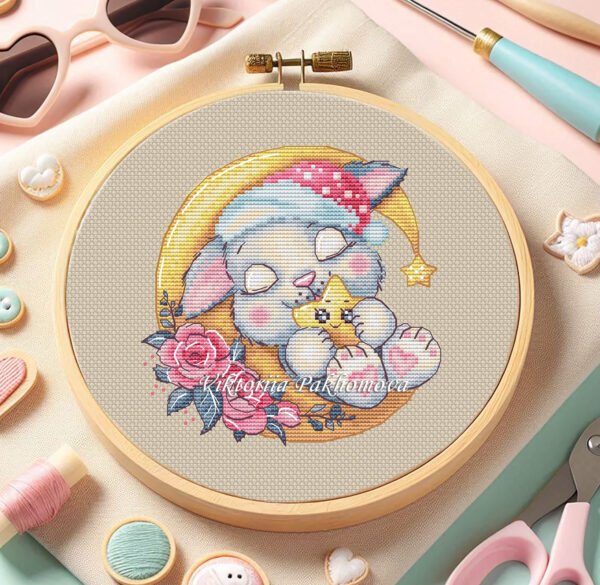 Cross stitch embroidery of a sleeping bunny displayed in a wooden hoop