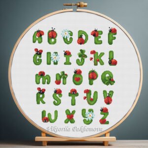 125 Cross stitch embroidery of a colorful ladybug alphabet with insect‑shaped letters displayed in a wooden hoop