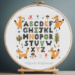 125 Cross stitch embroidery of a fox‑themed alphabet with woodland‑style letters displayed in a wooden hoop