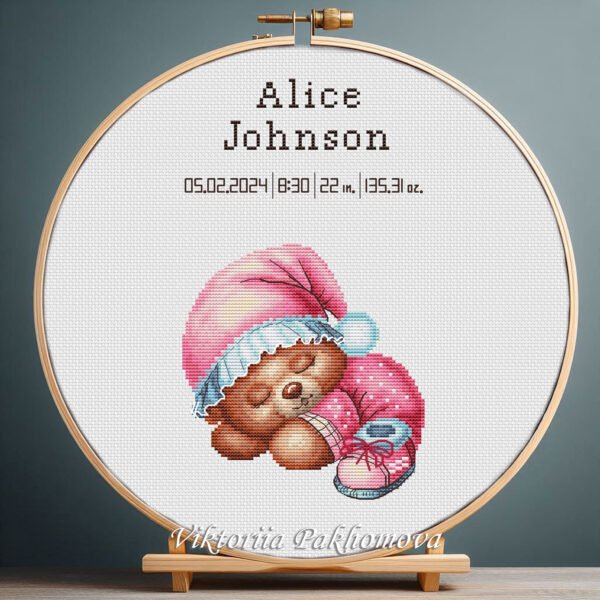 Cross stitch embroidery of a Sleeping Bear birth announcement with space for name, date and stats in a wooden hoop