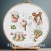 Cross stitch embroidery of a spring sampler with magic ice cream, spring coffee, floral boots, bouquet and a dreamy girl in a wooden hoop