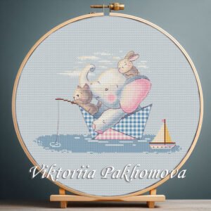 Cross stitch embroidery of an elephant, a bunny and a cat sitting in a small paper boat with soft pastel details in a wooden hoop