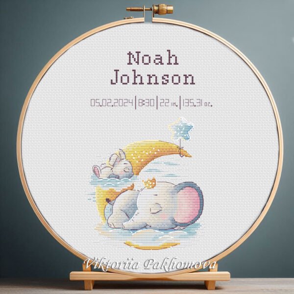 Cross stitch embroidery of a personalized bunny and elephant birth record displayed in a wooden hoop with custom newborn details.