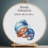 Cross stitch embroidery of a Teddy Bear birth announcement with space for name, date and stats in a wooden hoop