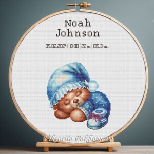Cross stitch embroidery of a Teddy Bear birth announcement with space for name, date and stats in a wooden hoop