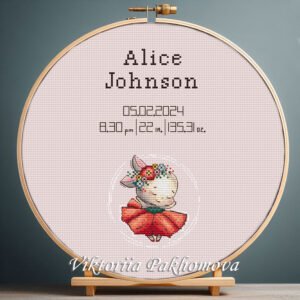Cross stitch embroidery of a personalized dancing bunny birth stats design displayed in a wooden hoop