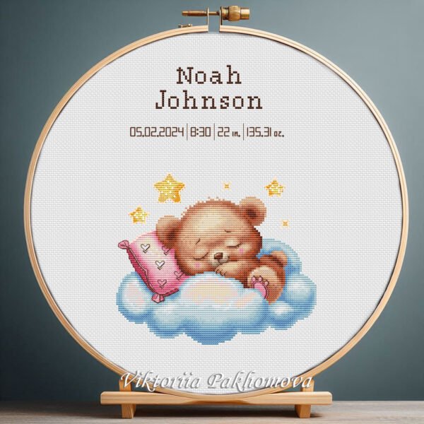 131 Cross stitch embroidery of a Sleeping Teddy Bear birth announcement with space for name, date and stats in a wooden hoop.