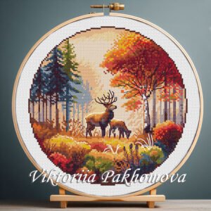 Autumn deer cross stitch pattern in an embroidery hoop, featuring two deer and colorful fall trees.
