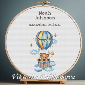 Cross stitch embroidery of a Teddy Bear with a balloon birth announcement with space for name, date and stats in a wooden hoop