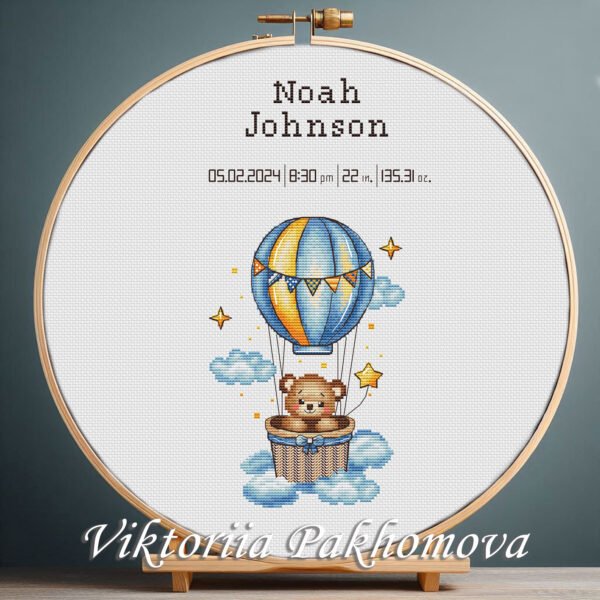 Cross stitch embroidery of a Teddy Bear with a balloon birth announcement with space for name, date and stats in a wooden hoop