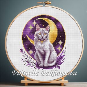 Moon Cat cross stitch pattern in a wooden hoop with crescent moon and stars