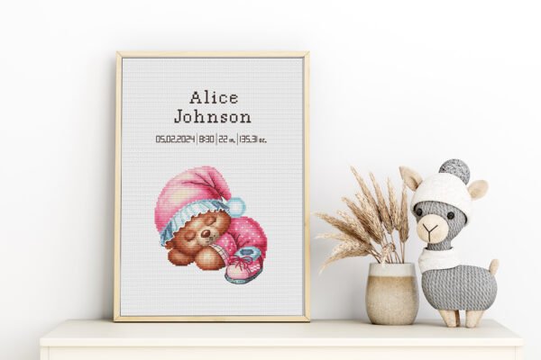 Framed Sleeping Bear cross stitch birth announcement with pastel colors and personalized baby details