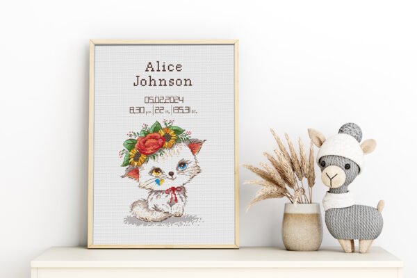Framed Baby Kitty cross stitch birth announcement with pastel colors and space for personalized baby details