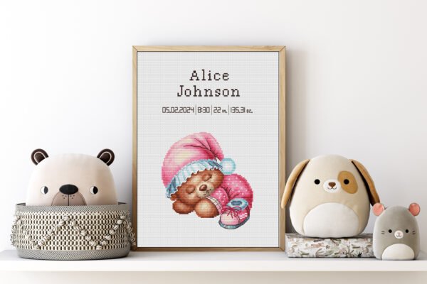 Framed Sleeping Bear cross stitch birth announcement with pastel colors and personalized baby details