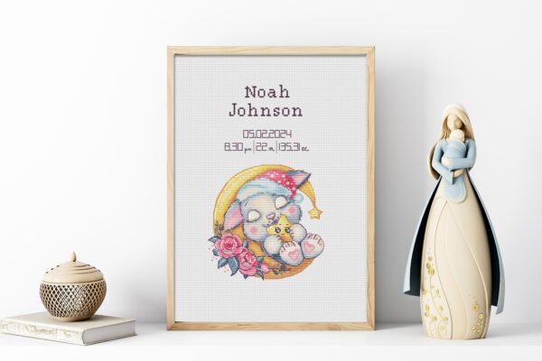 Framed sleeping bunny birth announcement cross stitch featuring personalized name, date and stats for nursery décor.