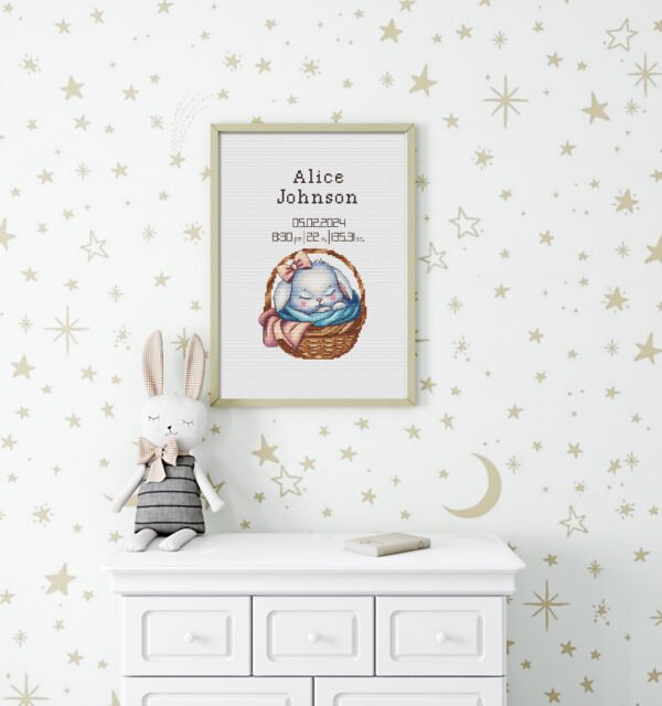 Framed baby girl birth announcement cross stitch featuring a sleeping bunny and personalized newborn details
