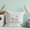Nursery pillow featuring a cross stitch design of an elephant, a bunny and a cat sailing in a paper boat with gentle pastel colors.