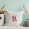 Mockup pillow in the children's room on light blue colors wall b Decorative pillow with an embroidered cross stitch design of a cute animal pattern, styled for cozy nursery décor.