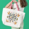 Tote bag with a fox alphabet cross stitch design showing cute woodland‑inspired letters in bright orange tones.