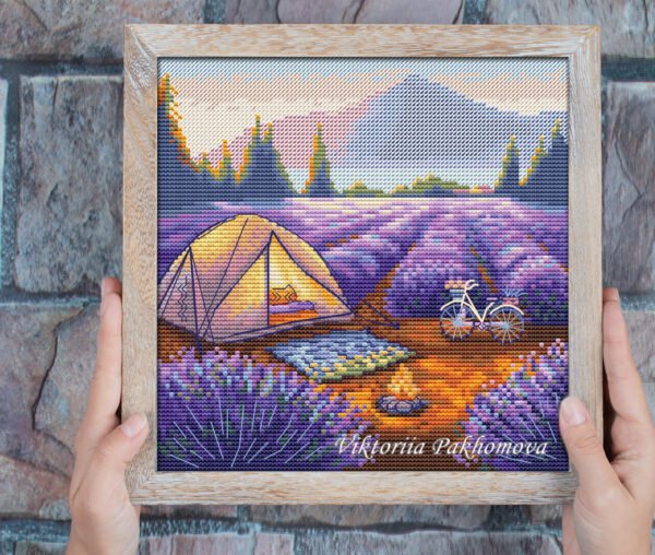 Framed cross stitch of a colorful lavender field camping landscape with mountains and sunset sky