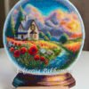 Framed cross stitch artwork showing a glass ball with a poppy field, warm sky and a small house