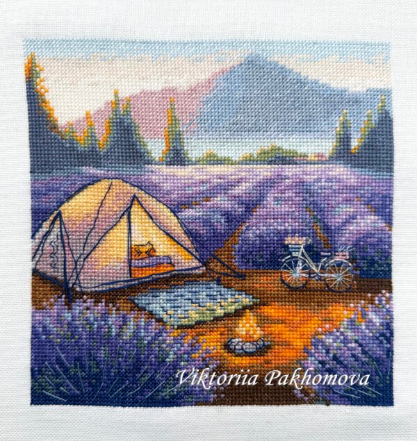 finished embroidery of a lavender camping scene with a tent, bicycle and mountains