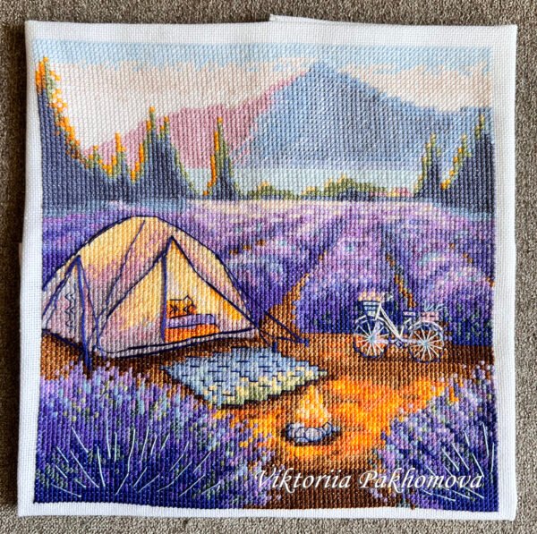 finished embroidery of a lavender camping scene with a tent, bicycle and mountains