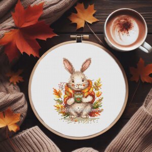 Autumn bunny cross stitch pattern in embroidery hoop with cozy scarf and fall leaves
