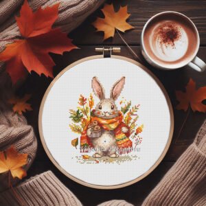 Autumn bunny cross stitch pattern in embroidery hoop with cozy scarf and fall leaves